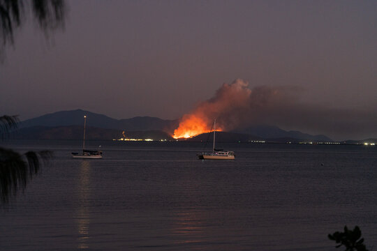 A fire is burning on the shore of a lake