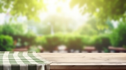  Empty wooden deck table with tablecloth with blur green courtyard background. - obrazy, fototapety, plakaty