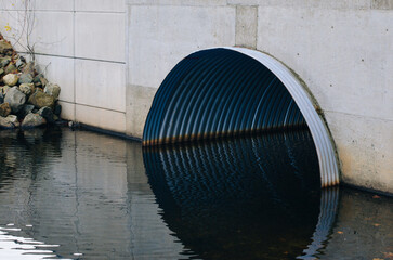 Drainage system under a highway. Metal pipe under a road. High-quality photo