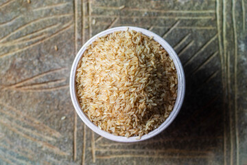 selective focus of raw brown rice on a rock background. 