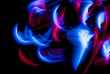 Abstract irregular blue and red lights on black background. Long exposure. Light painting...