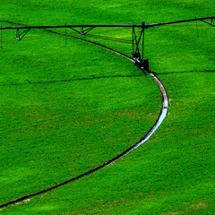 Irrigation Pivot in Lush Green Field with Circle Tracks on Ground