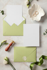 Wedding invitation cards mockups with olive envelopes, gold rings, flowers, wax seal stamp on stone...