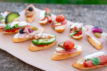 Finger food , various canapes with vegetables, ham, bacon , cheese and olives.