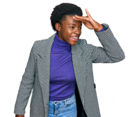 Young african american girl wearing casual clothes very happy and smiling looking far away with hand over head. searching concept.