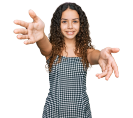 Teenager hispanic girl wearing casual clothes looking at the camera smiling with open arms for hug. cheerful expression embracing happiness.