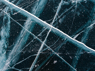 Aerial top down view on the blue cracked ice of the lake Baikal. Winter landscape, frozen lake. Ice...