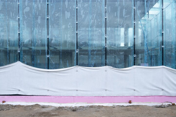 Glass wall at a construction site with insulated foundation