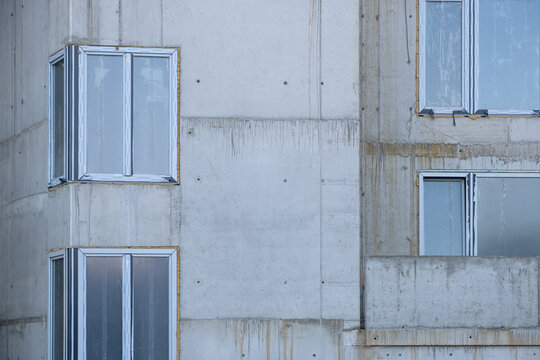 Windows installing Building work on the construction site in Europe. Modern Apartments Facade with windows. Not finished Architecture. growing building construction site