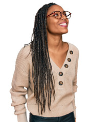 African american woman wearing casual clothes looking away to side with smile on face, natural...