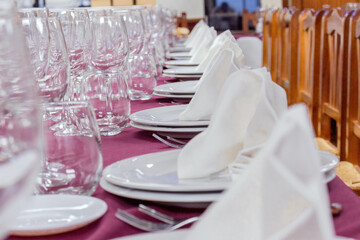Mesa de restaurante con vasos, platos y servilletas.