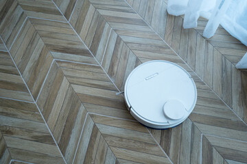 white modern robot vacuum cleaner at home interior on the floor