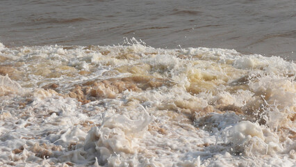 The foam of turbulent wave on the beach at Veli, Thiruvananthapuram, Kerala, India