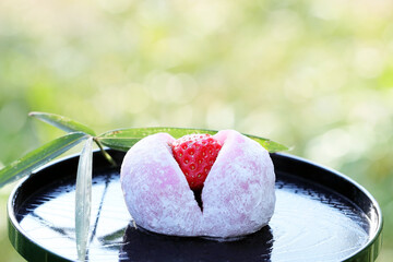 明るい緑を背景にした苺大福