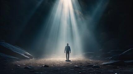 Man standing under celestial light rays - Mystical image of a man standing alone under powerful celestial light rays in a dark forest, evoking awe and wonder - obrazy, fototapety, plakaty