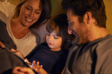 Night, parents or kid with tablet for streaming, playing games or watching videos on movie website in home. Social media, child or happy mom with dad or technology to download on ebook online in bed