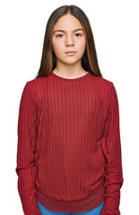 Beautiful brunette little girl wearing casual sweater relaxed with serious expression on face. simple and natural looking at the camera.