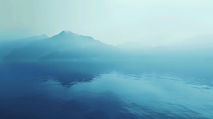 Naklejka premium This is a beautiful landscape image of a lake and mountains in the distance. The water is a deep blue color and the sky is foggy.