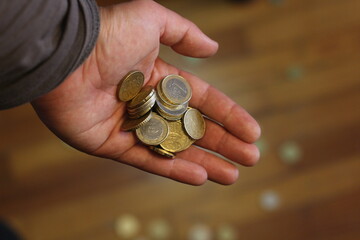 Grasping Value: Hand Holding Euro Coins Amidst Economic Uncertainty