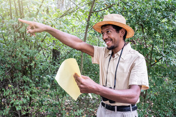 Forest guide with glowing smile, charting the path ahead. Guide points the way through a lush forest, holding a map. A cheerful leader in nature's embrace, pointing with enthusiasm.
