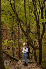 blonde woman hiker with backpack walking through a forest  for adventure backpacking in nature
