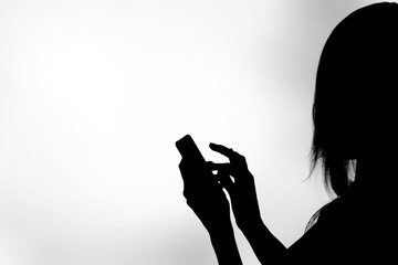 Dark human silhouette holds smartphone