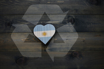 wooden heart with national flag of argentina near reduce, reuse and recycle sing on the wooden...