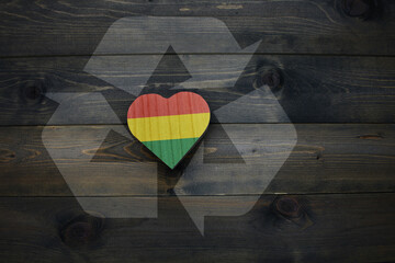 wooden heart with national flag of bolivia near reduce, reuse and recycle sing on the wooden...