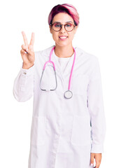 Young beautiful woman with pink hair wearing doctor uniform showing and pointing up with fingers number two while smiling confident and happy.