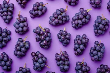  Ripe juicy grapes arranged in a flat lay composition on a vibrant purple background, top view shot © SHOTPRIME STUDIO