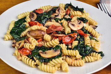 rotini served with spinach , mush rooms and tomatoes,
