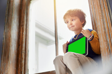 Home, tablet and kid with green screen on internet, app or mockup space for learning by windowsill. Technology, chroma key and child with display for advertising, marketing or thinking of idea - Powered by Adobe