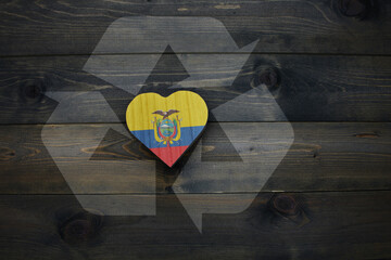 wooden heart with national flag of ecuador near reduce, reuse and recycle sing on the wooden...