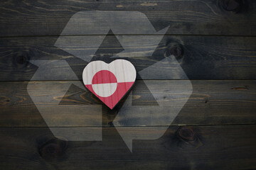 wooden heart with national flag of greenland near reduce, reuse and recycle sing on the wooden...