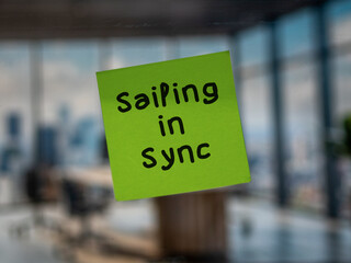 Post note on glass with 'Sailing in Sync'.