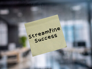 Post note on glass with 'Streamline Success'.
