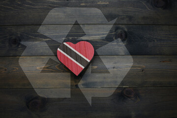 wooden heart with national flag of trinidad and tobago near reduce, reuse and recycle sing on the...
