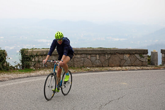young cyclist boy with protective helmet pedals uphill on a racing bicycle during the race