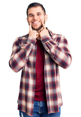 Young handsome man wearing casual shirt smiling with open mouth, fingers pointing and forcing cheerful smile