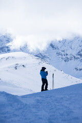 Fototapeta na wymiar Skier against mountains with clouds