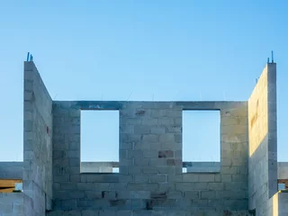 Fotobehang Window openings on top level of the concrete shell of a two-story single-family dwelling under construction in a suburban residential development on a sunny morning in southwest Florida © Kenneth