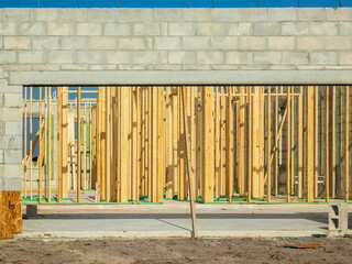 Parallel pattern of vertical wooden studs to support future walls inside the concrete shell of a...