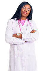 Young african american woman wearing doctor stethoscope looking to the side with arms crossed convinced and confident