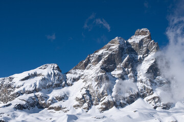 Mountain peak with snow against blue sky 