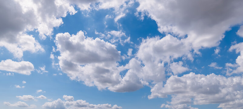 Panoramic view of clear blue sky and clouds, Blue sky background with tiny clouds. White fluffy clouds in the blue sky. Captivating stock photo featuring the mesmerizing beauty of the sky and clouds.
