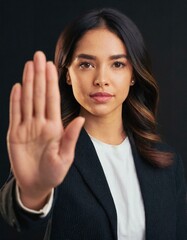 Close up of woman showing stop gesture with hand raising up on black background, young female protesting against domestic violence and abuse, bullying, saying no to gender discrimination