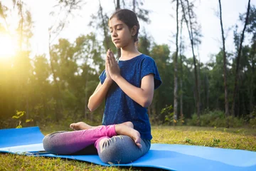 Kissenbezug indian serene girl enjoying yoga and morning sunlight sitting in a lotus position in the calm nature © Dharma