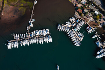 Aerial view of boats and beautiful city in Marmaris, Turkey. Landscape with boats in marina bay, sea, city lights, mountains. Top view from drone. 