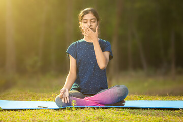 indian ethnicity women concentrating on pranayama meditation by focusing on breath inhale and...