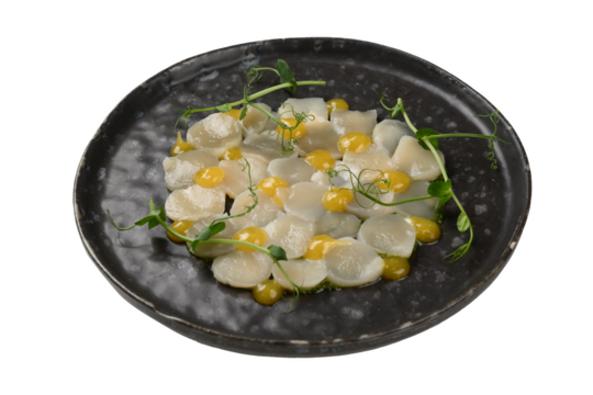 scallops sliced with sauce on a plate, carved out